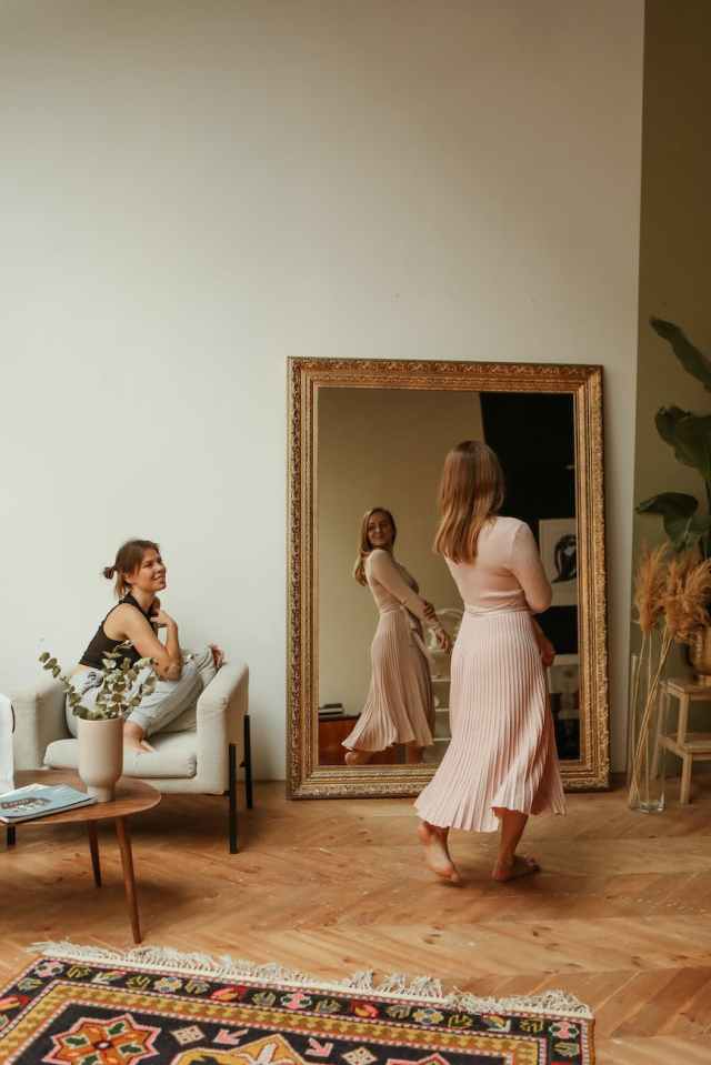 woman in dress looking in the mirror