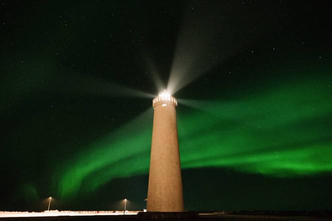 lighthouse against majestic green polar lights